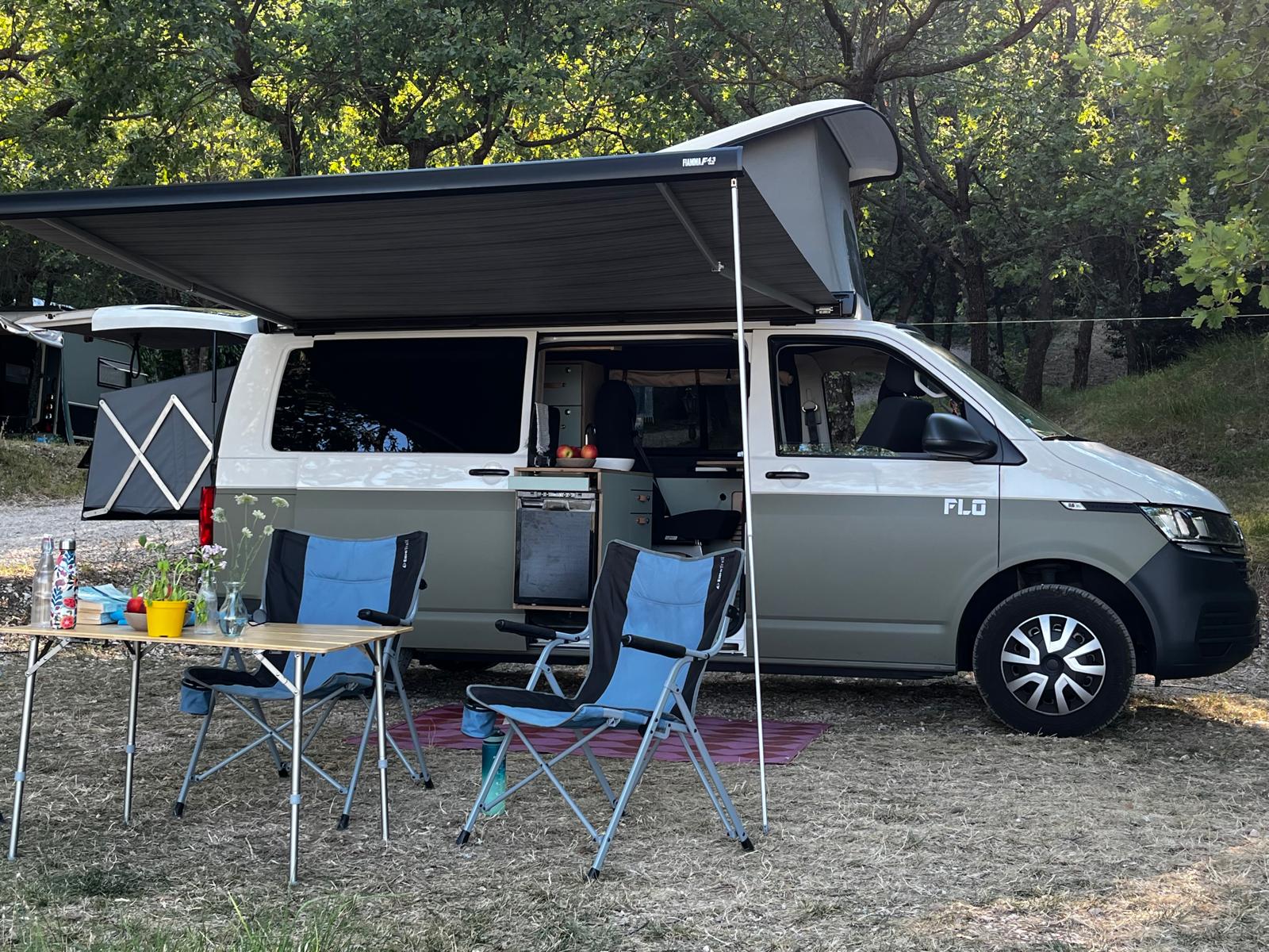 Wally-Van Air mit ausgeklappter Außenküche und Markise auf einem Campingplatz in Italien